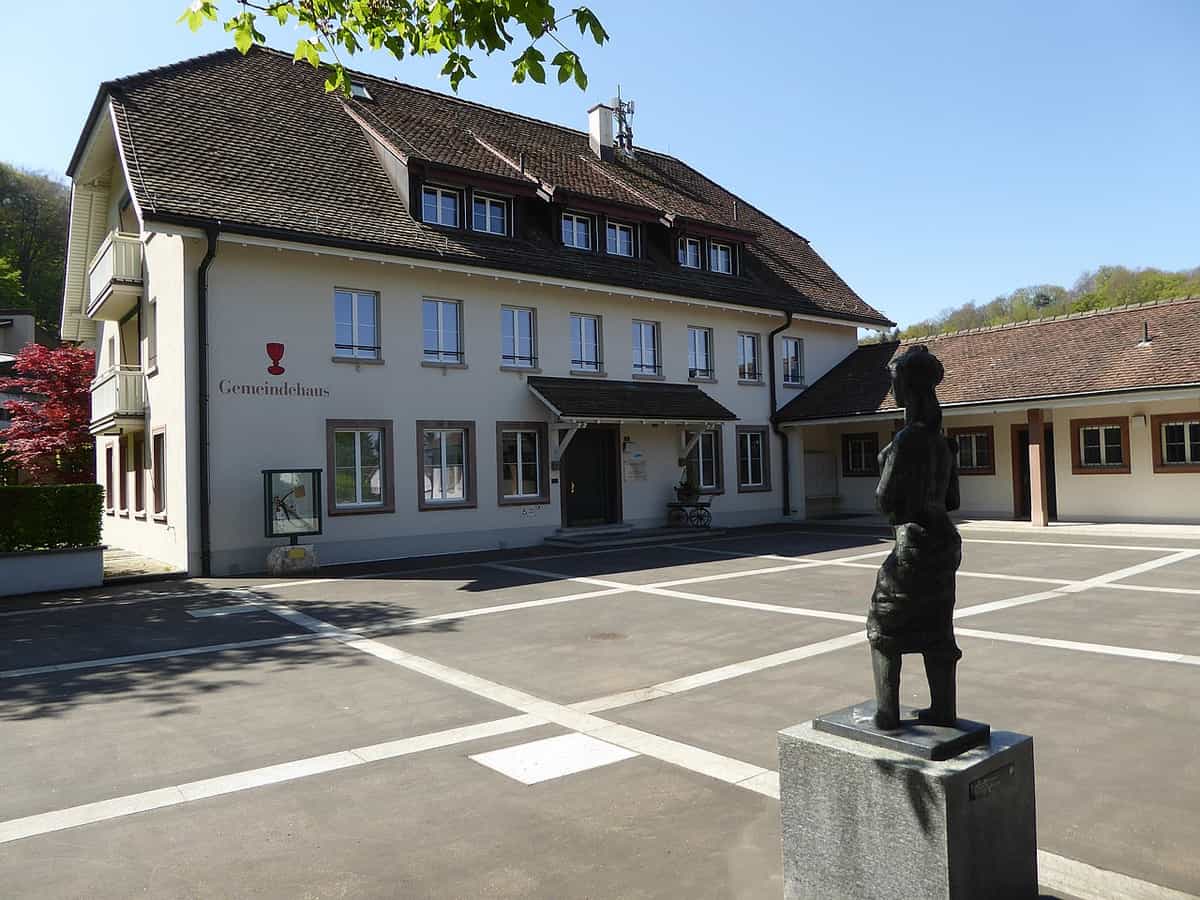 Gemeindehaus Bettingen, davor Carl Gutknecht (1878–1970) Bildhauer. Mutter mit Kind, 1969