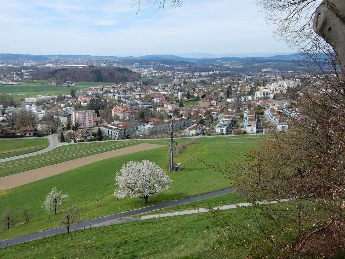 Bolligen: Übersicht der Ortschaft mit Kirche in der Mitte, im Hintergrund links die Stadt Bern
