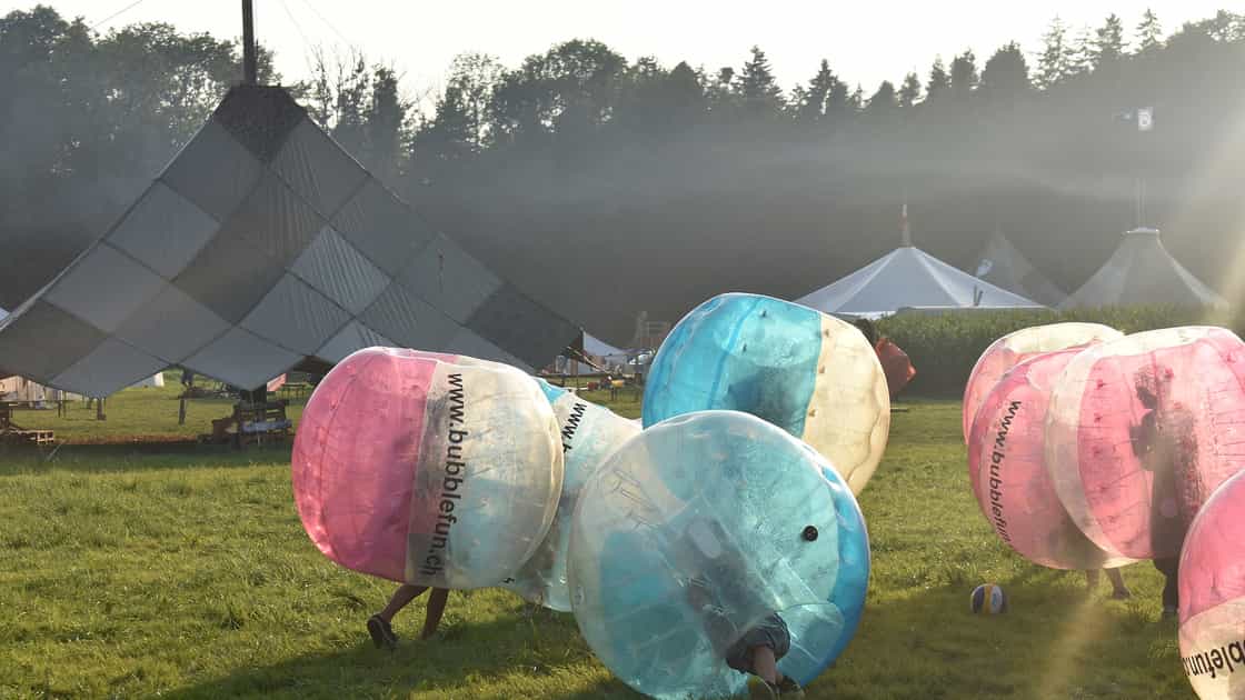 Kinder spielen Bubble-Soccer vor einem Lagerplatz mit grossem Sarasani.