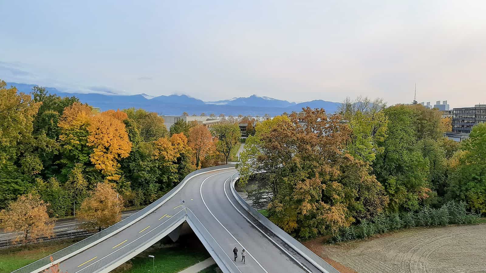 Blick vom Vortex-Gebäude auf die Alpen. Herbstfarben und geteilte Straße.