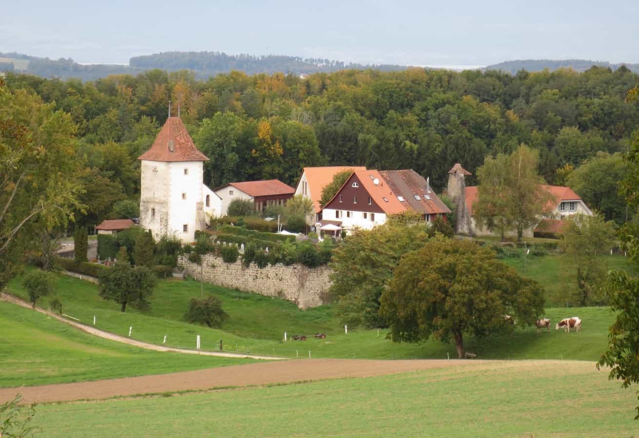 Der Turm von Villarzel links und die Kirche rechts, im Kanton Waadt, Schweiz
